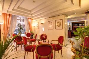 a waiting room with red chairs and a table at Hotel San Remo in Rome