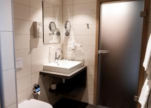 a bathroom with a sink and a toilet at Hotel Herbers Efemir GmbH in Südbrookmerland +80 photos