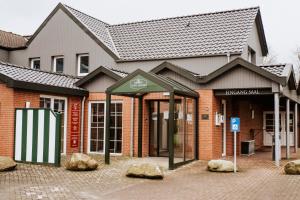a building with a bus stop in front of it at Hotel Herbers Efemir GmbH in Südbrookmerland