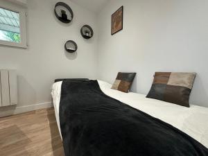 a bedroom with a large bed with black sheets and pillows at Le Roadtrip, cosy et calme in Saint-Junien