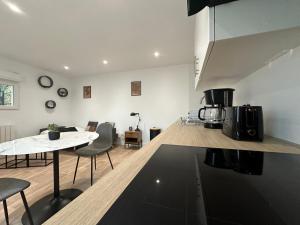 a kitchen and living room with a table and chairs at Le Roadtrip, cosy et calme in Saint-Junien +17 photos