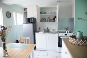 a kitchen with white appliances and a wooden table at Les bottines in Pont-d'Ouilly