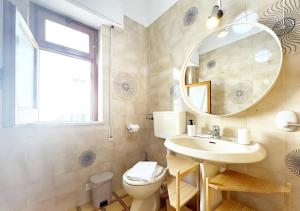 Un baño con lavabo, espejo e inodoro. en Solemar Sicilia - Ville Paradiso, en Santa Flavia 33 fotos más