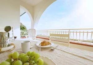 Una mesa con un plato de comida en un balcón. en Solemar Sicilia - Ville Paradiso, en Santa Flavia