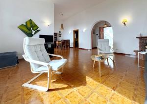 a living room with a white chair and a table at Solemar Sicilia - Ville Paradiso in Santa Flavia +52 photos