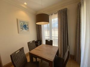 a dining room with a table and chairs and a window at Porto Montenegro Luxury Apartment in Tivat +9 photos