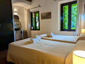 two beds in a room with two windows at Casa dentro del castillo de Tossa de Mar in Tossa de Mar