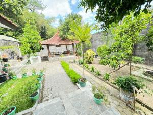 a garden with a gazebo with trees and plants at Rumah Organik Homestay Jogja in Ngaglik
