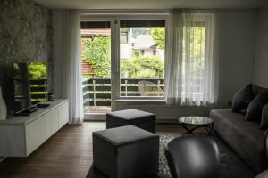 Una sala de estar con un sofá y una ventana grande. en Apartments Villa AnnaMaria, en Bled