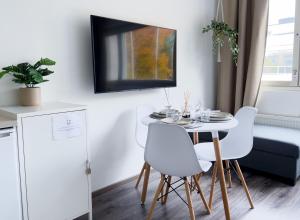 Un comedor con una mesa y sillas blancas. en Stylish Studio in the Centre, en Kuopio