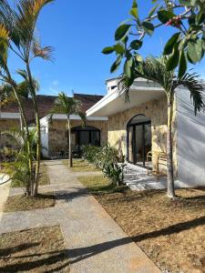 a house with palm trees in front of it at Palacio Balangan Villa in Uluwatu