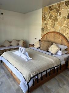 two beds in a room with two swans on them at Palacio Balangan Villa in Uluwatu +27 photos
