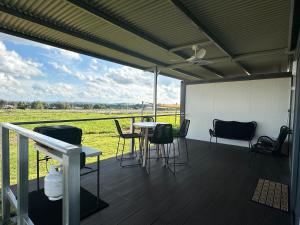 veranda con tavolo, sedie e vista su un campo di Valleyview Tiny House - Tamworth a Tamworth
