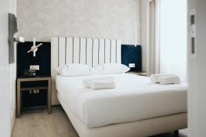 a bedroom with a large white bed with white pillows at M'AR De AR Auria in Lisbon