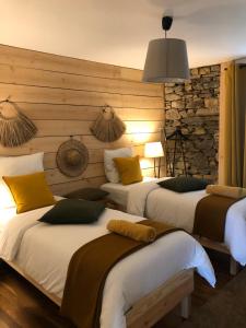two beds in a room with a stone wall at La Maison des Vignes - Terrasse & balcon in Morlaix