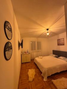 a bedroom with a white bed and a wooden floor at Aurora&Aziz Home in Galaţi