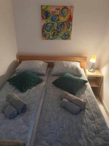 a bedroom with two beds with pillows and a painting at Apartman Djokic 3 in Požarevac