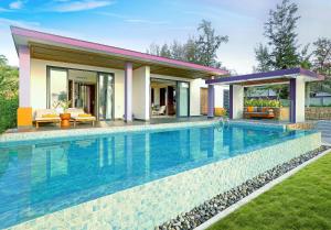 a swimming pool in front of a house at TTC Van Phong Bay Resort - Himalaya Sauna & Steam Retreat Included in Ninh Hòa +37 photos
