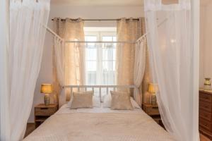 a bedroom with a canopy bed with a window at Pensjonat Well Clinic Medicine Estetic & Spa GDAŃSK in Gdańsk +75 photos