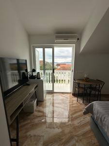 a bedroom with a bed and a table and a large window at Olive Luxury Apartments Orebić in Orebić
