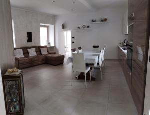 a kitchen and living room with a table and a couch at La Rocchetta - Ai piedi del Parco Naturale in Cavour