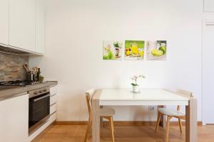 a kitchen with a white table and chairs at Nice Flat Milan 50m Station! in Milan +15 photos