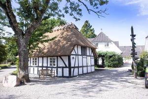 an old black and white building with a thatched roof at Gl. Brydegaard in Brydegård