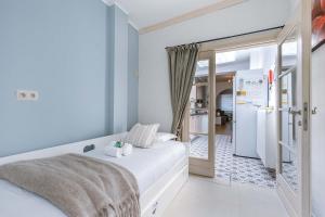 1 dormitorio con 1 cama blanca y nevera en Huswell - Spacious apartment with terrace, Pets are welcome, en Ostende