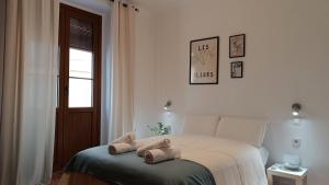 Un dormitorio con una cama con dos animales de peluche encima. en Sherryflat Torán, en Jerez de la Frontera