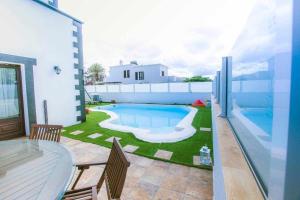 a large swimming pool in a yard next to a house at Villa Palacios Herrero in Tahiche