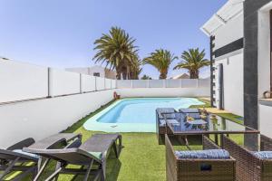 a patio with chairs and a swimming pool at Villa Palacios Herrero in Tahiche