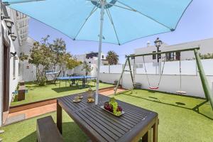 a patio with a table and a swing and an umbrella at Villa Palacios Herrero in Tahiche +12 photos
