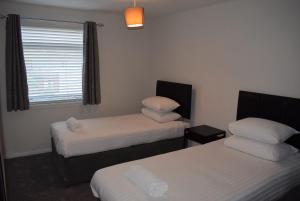 a room with two beds and a window at 3 Bedroom-Kelpies Serviced Apartments Burns in Falkirk