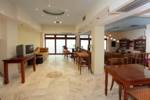 ein Wohnzimmer mit Sofa, Tisch und Stühlen in der Unterkunft Afroditi in Rethymno