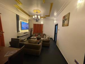 a living room with couches and a chandelier at FandDapartments in Port Harcourt +6 photos