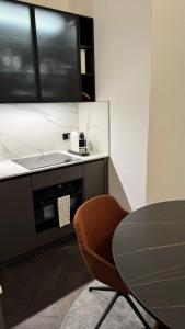 a kitchen with a table and a tv and a chair at Exklusive Wohnung im Herzen Münchens in Munich