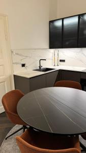 a kitchen with a table and chairs and a sink at Exklusive Wohnung im Herzen Münchens in Munich +36 photos
