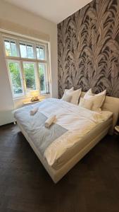 a large bed in a bedroom with a wall at Exklusive Wohnung im Herzen Münchens in Munich