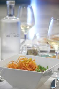 a white bowl of pasta on a table with wine glasses at Hotel Villa Adriana in Monterosso al Mare