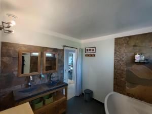 un bagno con vasca, lavandino e specchio di Maison 100m2 Au Cœur de Dosches a Dosches