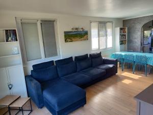 un soggiorno con un divano blu e un tavolo di Maison 100m2 Au Cœur de Dosches a Dosches Altre 15 foto