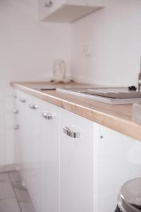 a kitchen with white cabinets and a wooden counter top at Zajazd Hetmański-Noclegi-Nowy Wiśnicz in Nowy Wiśnicz