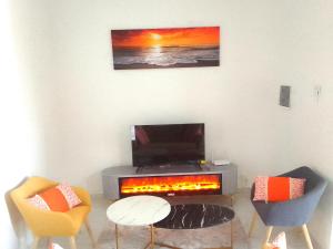 a living room with a fireplace and two chairs at La Rouah Mishkan in Dakar
