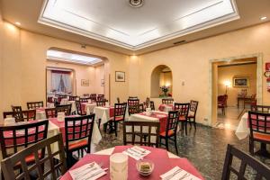 a restaurant with tables and chairs in a room at Hotel San Remo in Rome