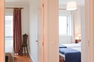 pokój hotelowy z 2 łóżkami i oknem w obiekcie Apartamento Com Vista Para O Mar w Porto