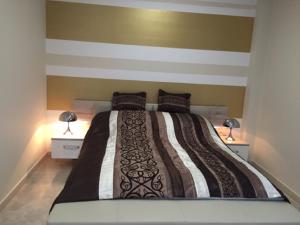 a bedroom with a large bed with two lamps at Apartament Nina in Wisła