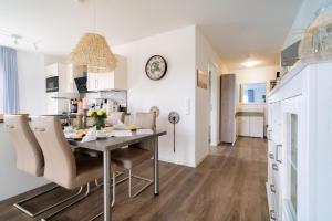 a dining room and kitchen with a table and chairs at Seebreeze 50 2 N in Wangerland