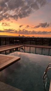 una piscina in cima a un edificio con tramonto di Inova Flat no centro a Palmas