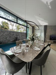 a dining room with a table and chairs at The Langkawi Luxury - Private Pool Villas & Rooftop Sunset in Pantai Cenang