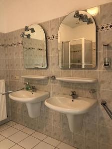 un baño con dos lavabos y dos espejos en Wiehengebirgs Fernblick App 4, en Bad Essen 19 fotos más